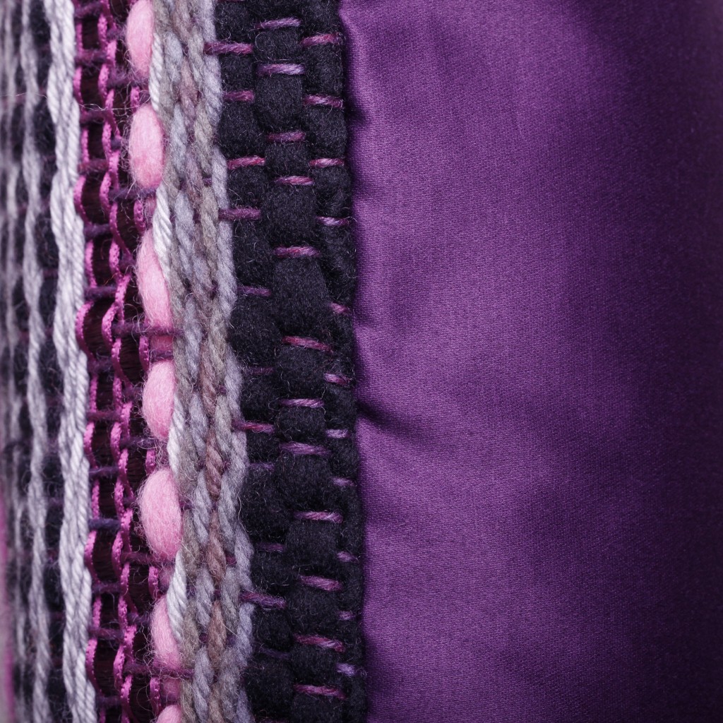 Détail du profil du coussin "BOMBAY" : tissage artisanal et satin de coton lie de vin