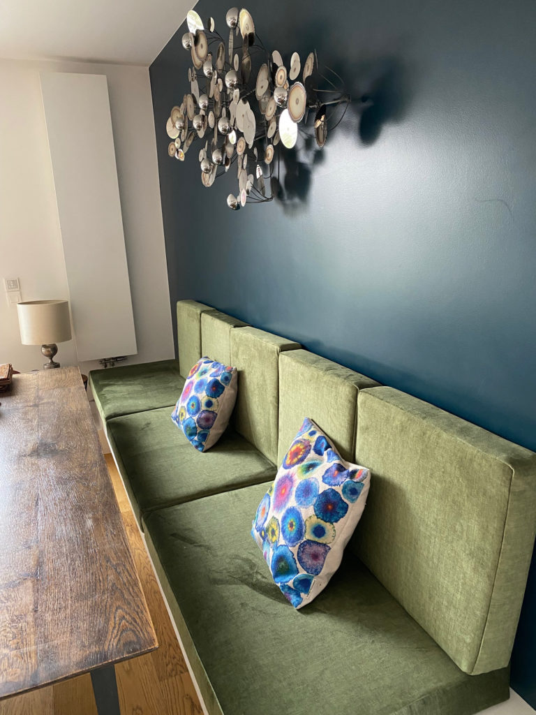 banquette sur mesure en velours vert avec coussins décoratifs colorés – réalisation Maison du Coussin – salle à manger contemporaine
