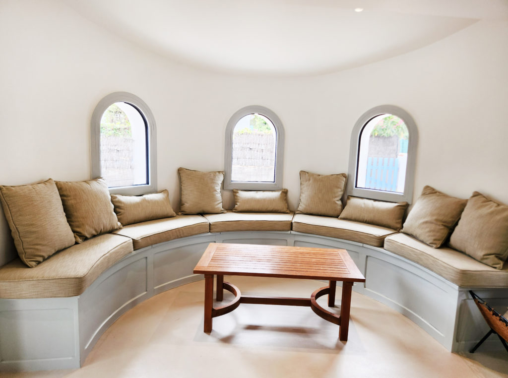 coussins sur mesure beige foncé pour banquette arrondie dans salon de maison bord de mer