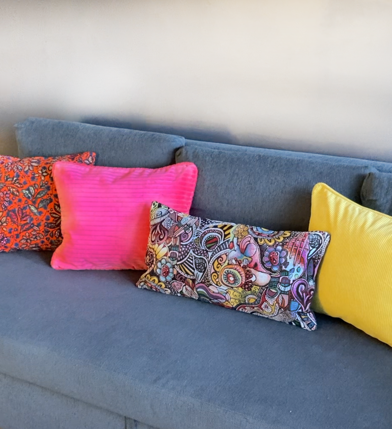 Coussin rose fluo sur canapé gris